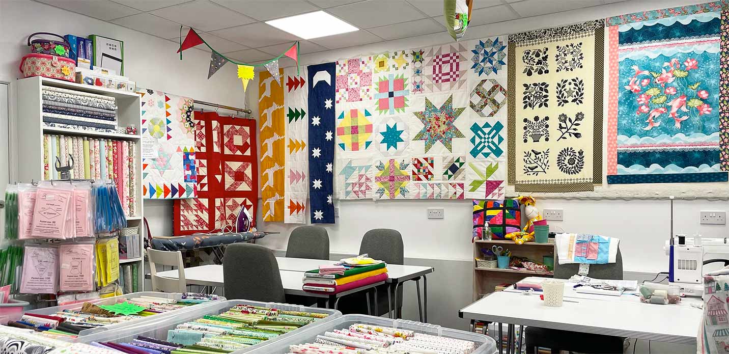Craft sewing area with quilts, kits and fabrics and workshop tables